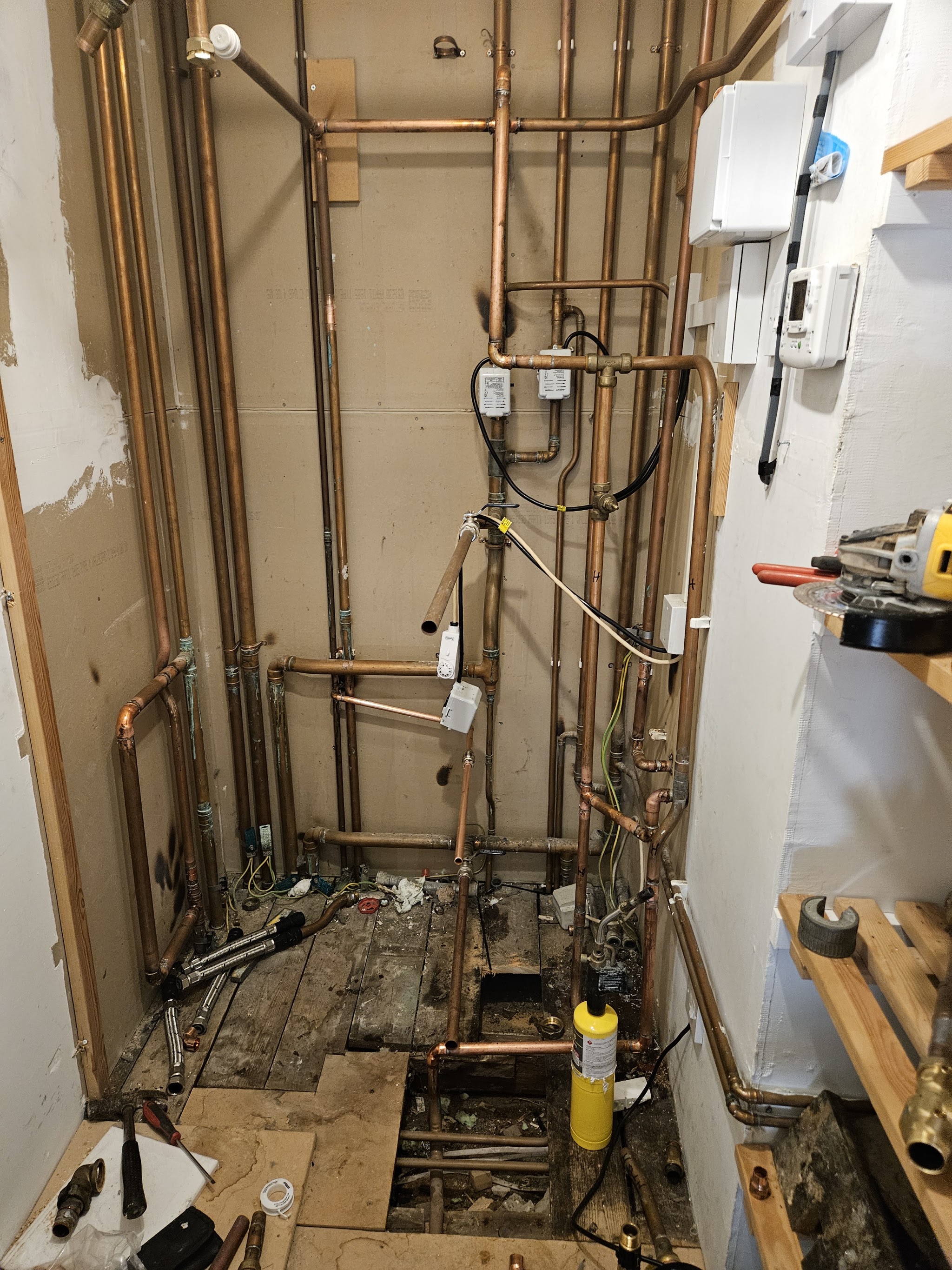 First-fix copper pipework in an open stud wall with the floorboards up