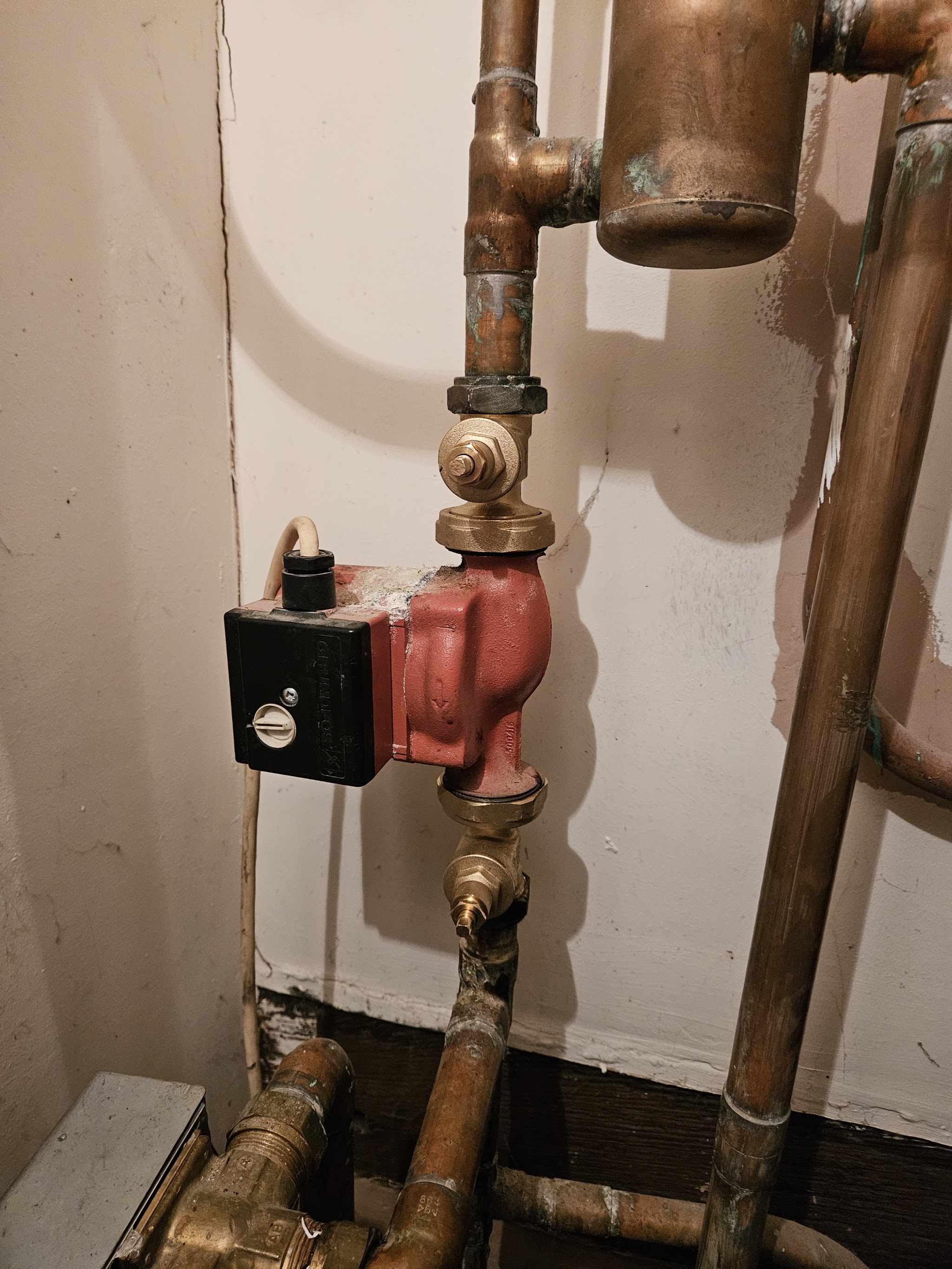 A central heating circulating pump with copper pipework and a brass valve